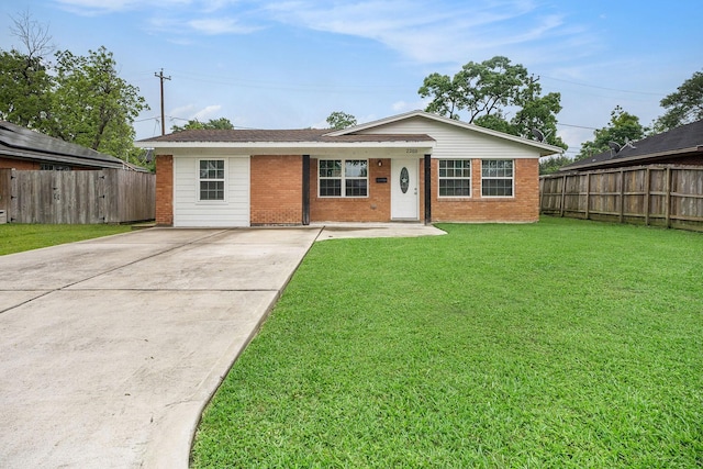 view of front facade with brick siding, fence, a front yard, and concrete driveway