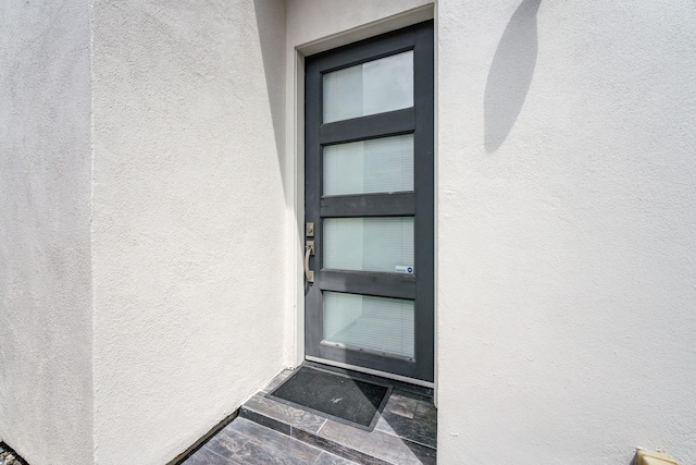 view of exterior entry featuring stucco siding