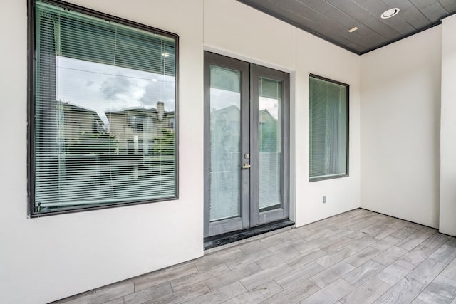 view of exterior entry with a patio, stucco siding, and french doors
