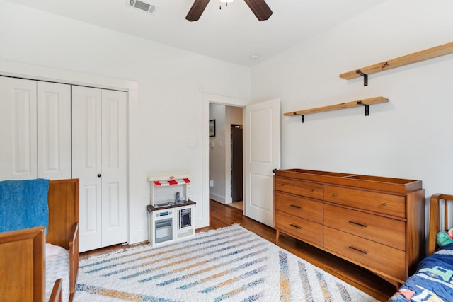 bedroom featuring a ceiling fan, a closet, wood finished floors, and visible vents