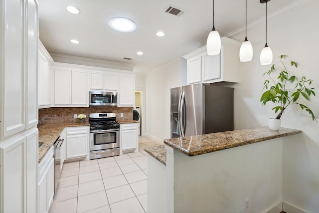 kitchen with crown molding, white cabinets, appliances with stainless steel finishes, and tasteful backsplash