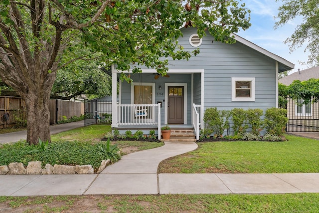 view of front of home with fence, a porch, and a front yard
