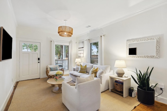 living area with crown molding, baseboards, and visible vents