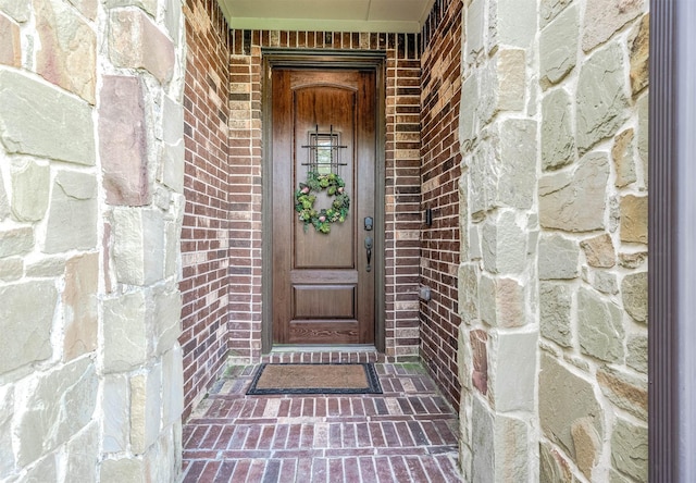 doorway to property with brick siding and stone siding
