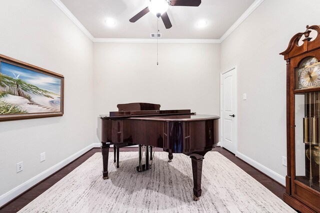 living area featuring visible vents, ornamental molding, baseboards, ceiling fan, and dark wood-type flooring