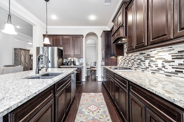 kitchen with visible vents, arched walkways, appliances with stainless steel finishes, dark brown cabinets, and a sink