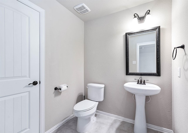 bathroom featuring visible vents, tile patterned flooring, toilet, baseboards, and a sink