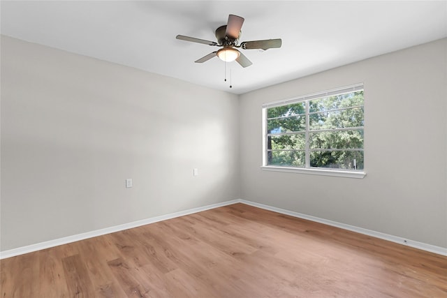 empty room with baseboards, ceiling fan, and light wood-style flooring