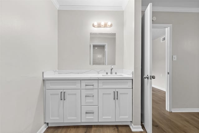 bathroom with baseboards, ornamental molding, and wood finished floors