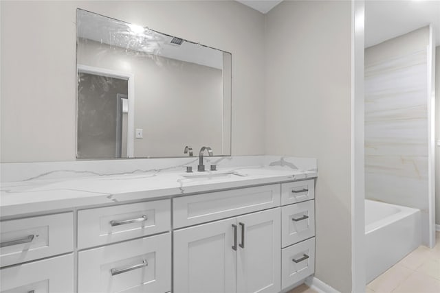 full bathroom featuring tile patterned floors, a bathtub, and vanity