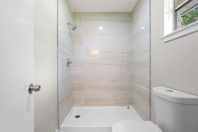 full bathroom featuring toilet and tiled shower
