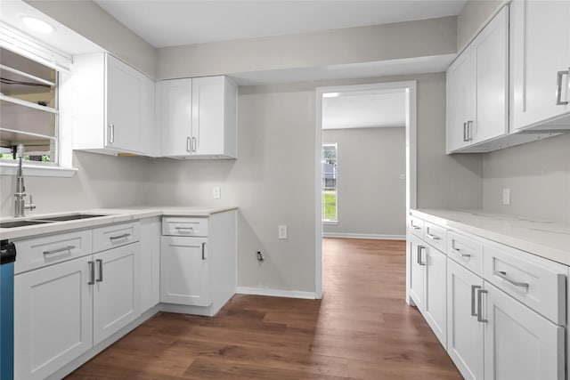 kitchen featuring dark wood-type flooring, a sink, and white cabinets