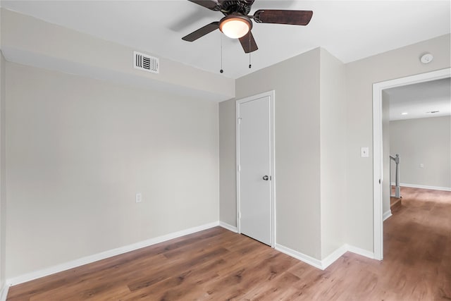 unfurnished bedroom featuring visible vents, a ceiling fan, baseboards, and wood finished floors