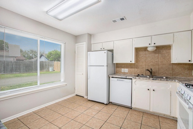 3622 Pine Ridge Ln, Houston, TX 77088 - kitchen with a sink, white appliances, white cabinetry, decorative backsplash, and visible vents