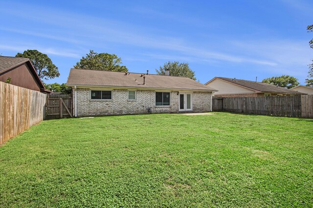 3622 Pine Ridge Ln, Houston, TX 77088 - back of house featuring a fenced backyard, a lawn, and brick siding