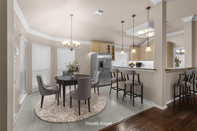 2215 Bay Haven Way, League City, TX 77573 - dining area featuring a chandelier, ornamental molding, vaulted ceiling, baseboards, and light wood-style flooring