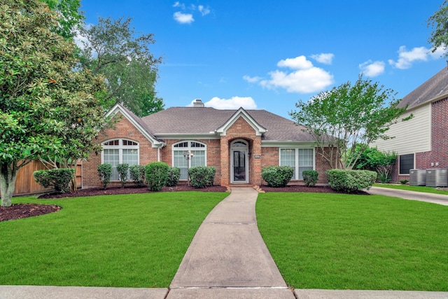 2215 Bay Haven Way, League City, TX 77573 - view of front of property with brick siding, a front lawn, roof with shingles, and central air condition unit