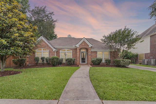 2215 Bay Haven Way, League City, TX 77573 - view of front of property with brick siding, roof with shingles, a yard, and central AC