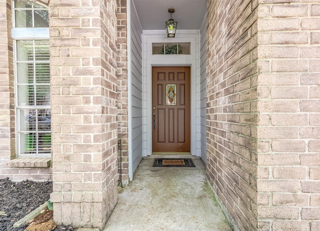 doorway to property featuring brick siding
