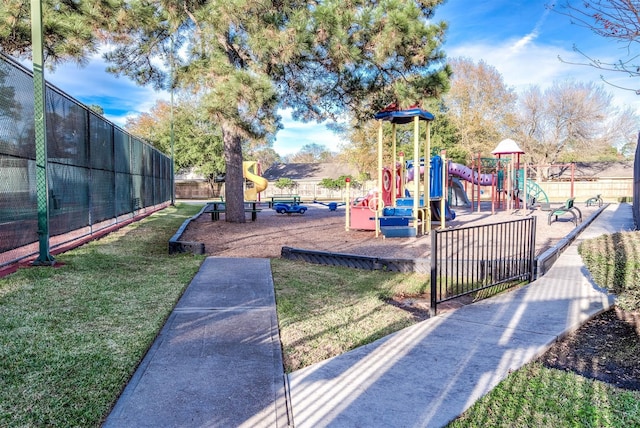 community jungle gym featuring a yard and fence
