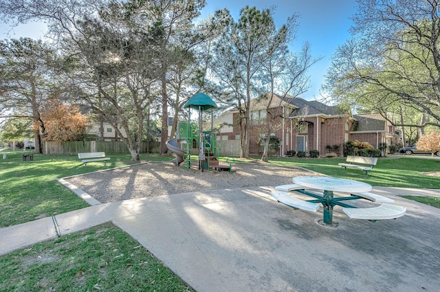 community jungle gym with a lawn and fence