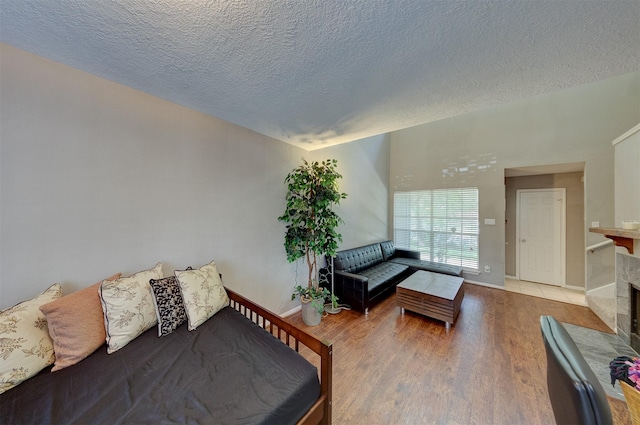 living area featuring baseboards, a textured ceiling, and wood finished floors