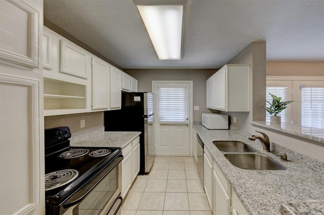 kitchen with a sink, electric range, white microwave, and white cabinets