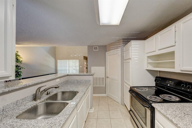 kitchen featuring a sink, white cabinets, light stone counters, electric stove, and light tile patterned floors