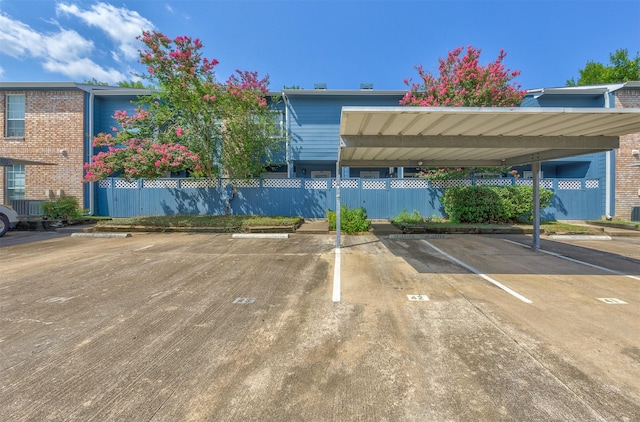 covered parking lot featuring fence