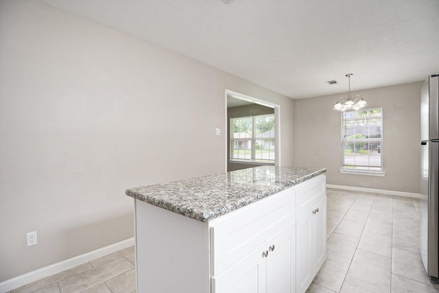 kitchen featuring baseboards, light stone counters, and plenty of natural light