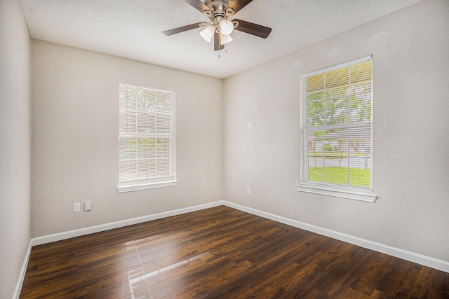 empty room with baseboards, dark wood-style floors, ceiling fan, and plenty of natural light