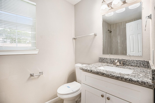 full bathroom featuring vanity, a shower, and toilet