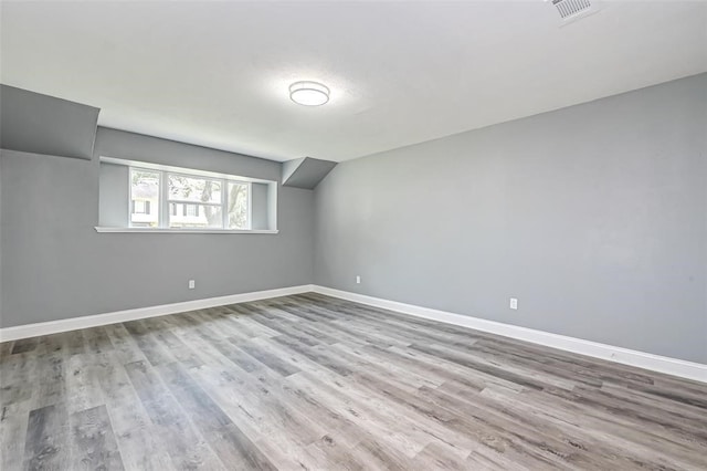 bonus room featuring visible vents, baseboards, and wood finished floors
