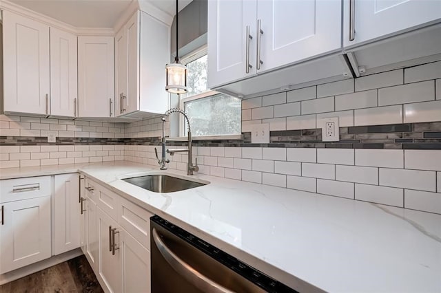 kitchen featuring white cabinets, light stone counters, a sink, dishwasher, and backsplash