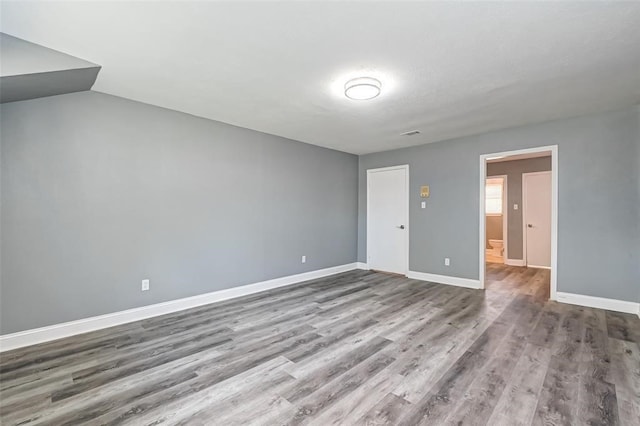 unfurnished room featuring baseboards and wood finished floors