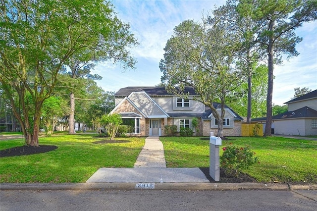 view of front of home with brick siding and a front yard