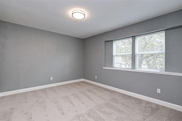 carpeted spare room featuring baseboards