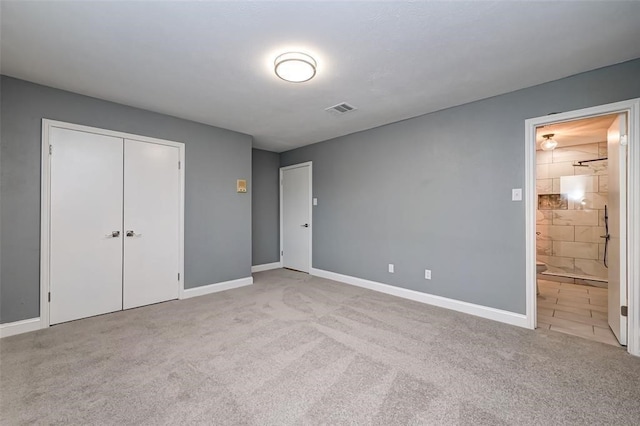 unfurnished bedroom featuring visible vents, baseboards, a closet, connected bathroom, and carpet