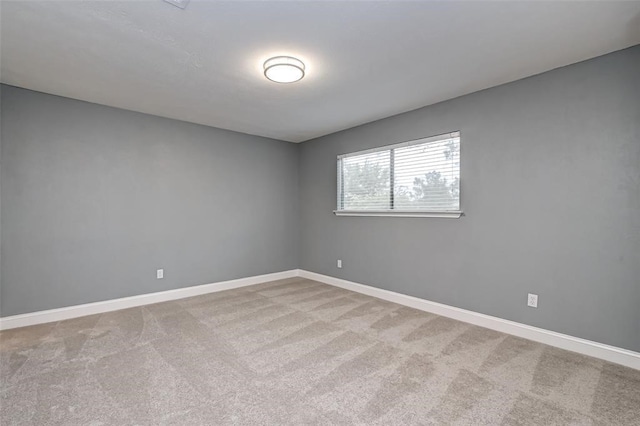 spare room featuring baseboards and carpet