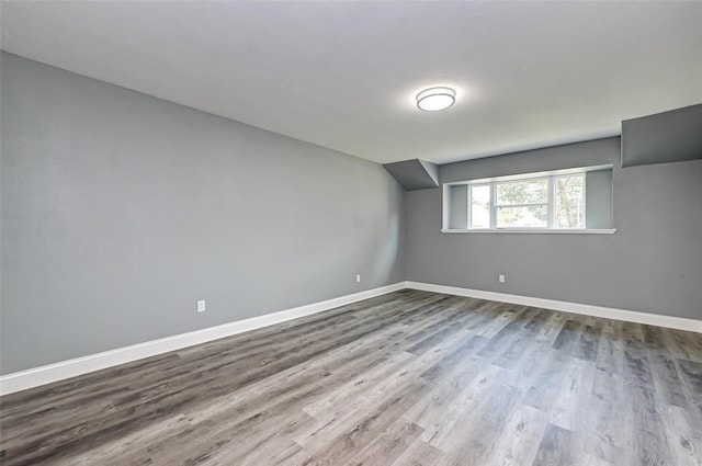bonus room with baseboards and wood finished floors