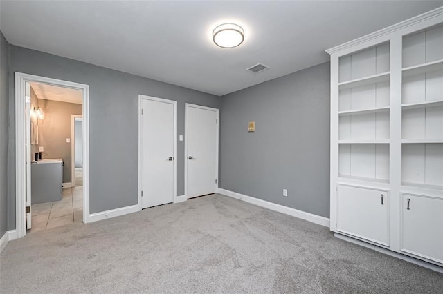 unfurnished bedroom featuring two closets, baseboards, and carpet