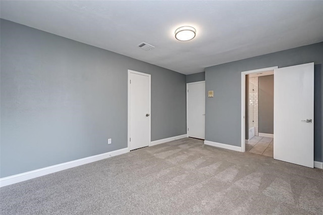 unfurnished bedroom with carpet floors, baseboards, and visible vents
