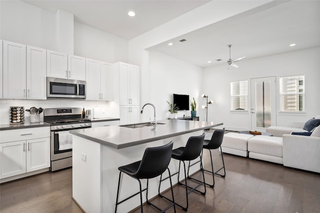 1023 Roberts St, Houston, TX 77003 - kitchen with stainless steel appliances, a sink, open floor plan, dark wood-type flooring, and a kitchen bar