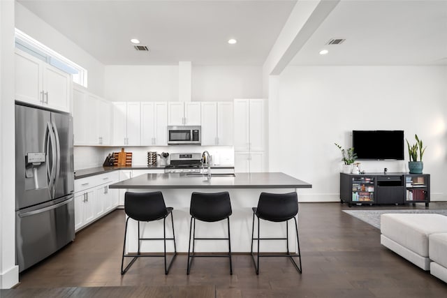 1023 Roberts St, Houston, TX 77003 - kitchen featuring stainless steel appliances, open floor plan, a sink, a kitchen breakfast bar, and dark countertops