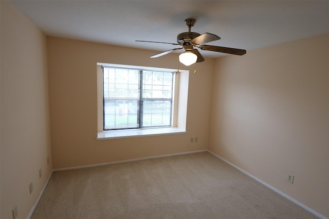 unfurnished room with light colored carpet, baseboards, and ceiling fan