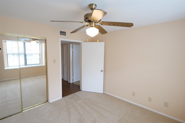 unfurnished bedroom featuring ceiling fan, carpet floors, baseboards, visible vents, and a closet