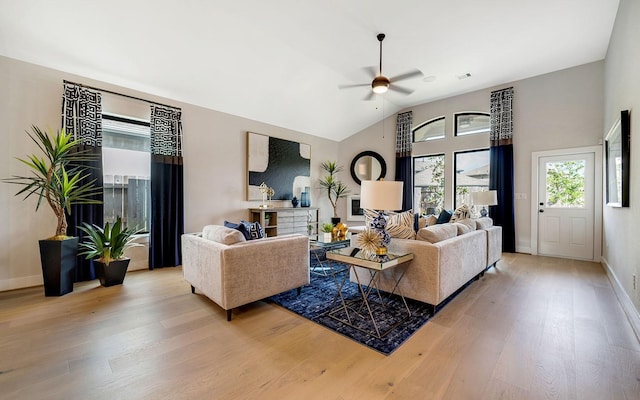 living room with baseboards, light wood-style flooring, ceiling fan, and vaulted ceiling