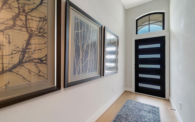entryway with baseboards and wood finished floors