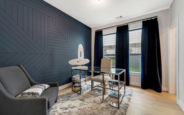 office with wooden walls, baseboards, light wood-style flooring, and visible vents