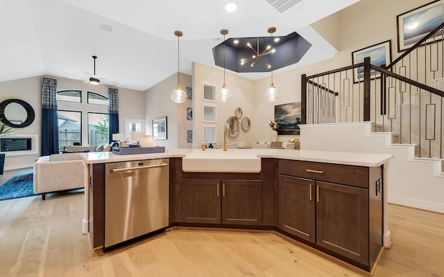 kitchen featuring a sink, light wood finished floors, dishwasher, light countertops, and open floor plan